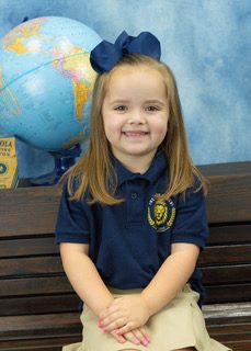 A VPK student in her Rock Academy uniform at her desk